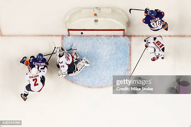 Cal Clutterbuck of the New York Islanders shoots the puck past Braden Holtby of the Washington Capitals for a first period goal at the Barclays...