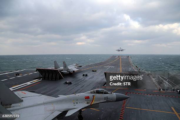 This photo taken on December 23, 2016 shows Chinese J-15 fighter jets being launched from the deck of the Liaoning aircraft carrier during military...