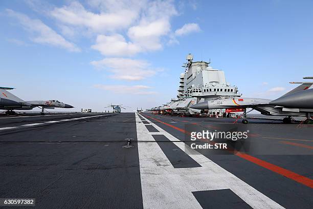 This photo taken on December 23, 2016 shows Chinese J-15 fighter jets on the deck of the Liaoning aircraft carrier during military drills in the...