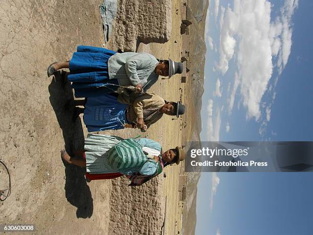 Three peasant women in the prairie. Indigenous women from Juliaca in the Peruvian altiplano, use to meet to weave traditional products to market them...