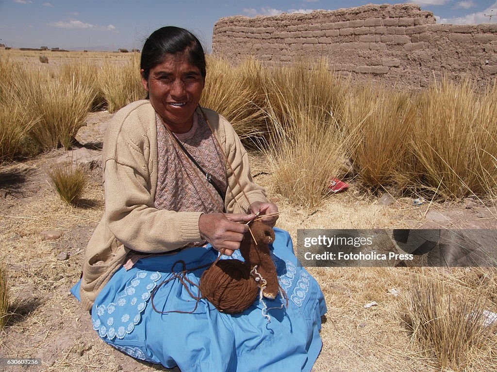 A peasant woman knitting in the prairie. Indigenous women...