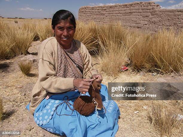 Peasant woman knitting in the prairie. Indigenous women from Juliaca in the Peruvian altiplano, use to meet to weave traditional products to market...