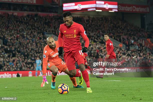 Liverpool's Daniel Sturridge goes around Stoke City's goalkeeper Lee Grant to score his sides fourth goal during the Premier League match between...