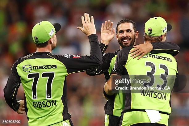 Fawad Ahmed of the Thunder celebrates with team mates after claiming the wicket of Jason Floros of the Heat during the Big Bash League match between...