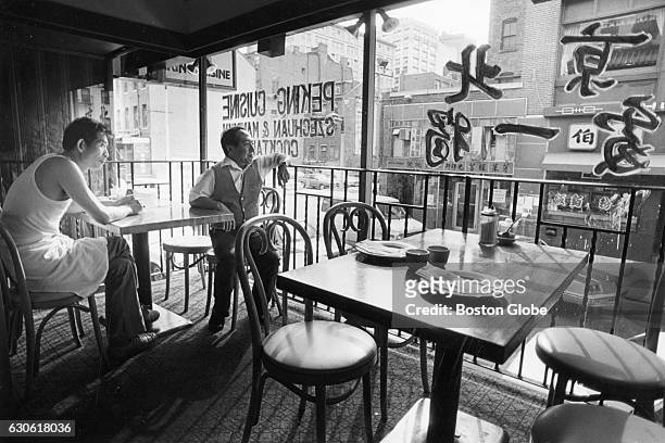 Sia Mai Tsao and Peter Yen look at the street from the window in the Peking Cuisine Restaurant in Boston's Chinatown before the dinner shift on Aug....
