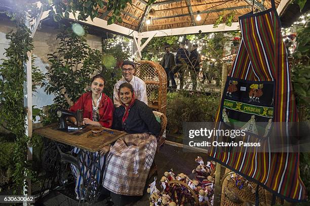 Three persons with the Madeira Island traditional costume poses for the picture in the city during Christmas celebrations on December 29, 2016 in...