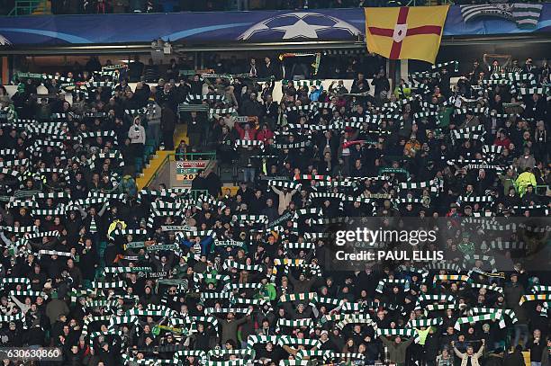 Celtic fans hold up team scarves in the stands during the UEFA Champions League group stage football match between Celtic and Barcelona at Celtic...