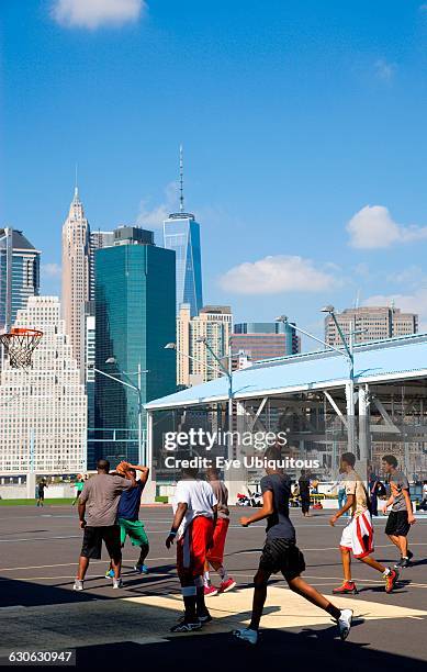 New York, Brooklyn Bridge Park basketball courts on Pier 2 with Lower Manhattan skyscraper skyline beyond.