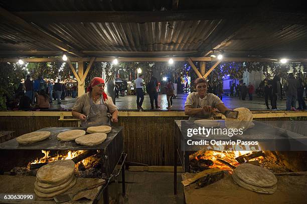 Two womans cooks the Bolo de Caco, which is a shard wheat bread typical of the region of Madeira Island, on December 29, 2016 in Funchal, Madeira,...