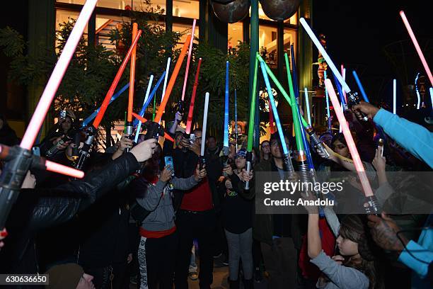 Hundreds of fans of actress and writer Carrie Fisher and her mother actress Debbie Reynolds hold lightsabers up in memory of actresses at Lightsaber...