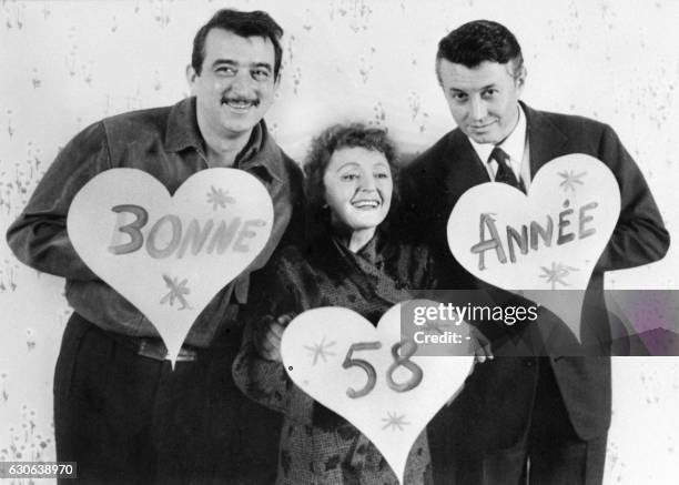 La chanteuse Edith Piaf pose avec ses partenaires Armand Mestral et Michel Auclair, le 30 décembre 1957 à Paris, pour souhaiter une bonne année 1958...