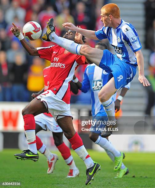 Wigan Athletic's English midfielder Ben Watson vies with Arsenal's Cameroonian player Alex Song during their English Premier League football match at...