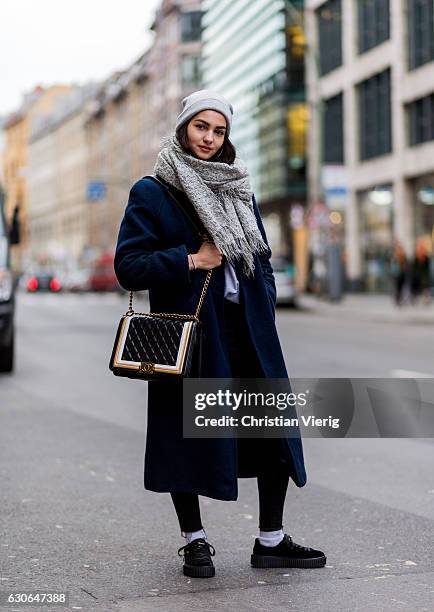 Kim Chiara Trombin wearing a grey beanie, grey scarf with fringes, navy blue wool coat, Puma sneaker shoes, black golden Chanel bag on December 29,...