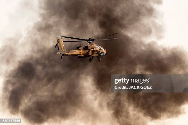 An Israeli AH-64 Apache longbow helicopter performs in an air show during the graduation ceremony of Israeli air force pilots at the Hatzerim base in...