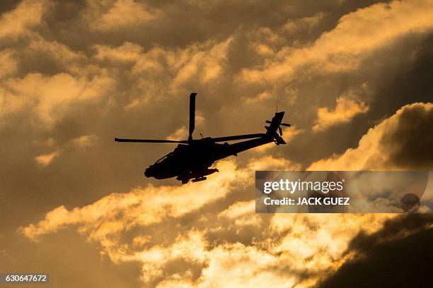 An Israeli AH-64 Apache longbow helicopter performs in an air show during the graduation ceremony of Israeli air force pilots at the Hatzerim base in...