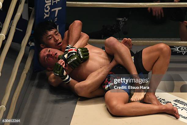 Tatsumitau Wada of Japan attempts to secure rear choke submission in the bout against Kai Kara-France of New Zealand during the RIZIN Fighting World...