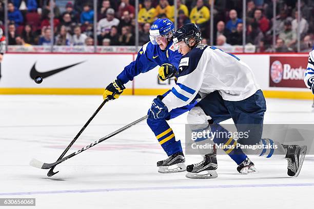 Olli Juolevi of Team Finland and Fredrik Karlstrom of Team Sweden skate after the puck during the 2017 IIHF World Junior Championship preliminary...