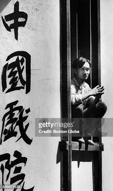 Vou Cuong Rem sits in the window of a Chinese movie theater on Beach Street in Boston's Chinatown on Sept. 5, 1987.