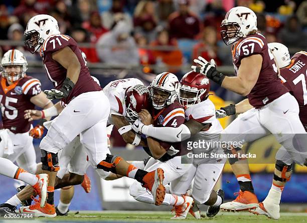 Jerod Evans of the Virginia Tech Hokies is tackled by the Arkansas Razorbacks during the Belk Bowl at Bank of America Stadium on December 29, 2016 in...