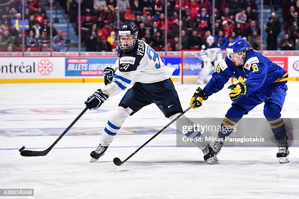 Kristian Vesalainen of Team Finland plays the puck past Rasmus Asplund of Team Sweden during the 2017 IIHF World Junior Championship preliminary...