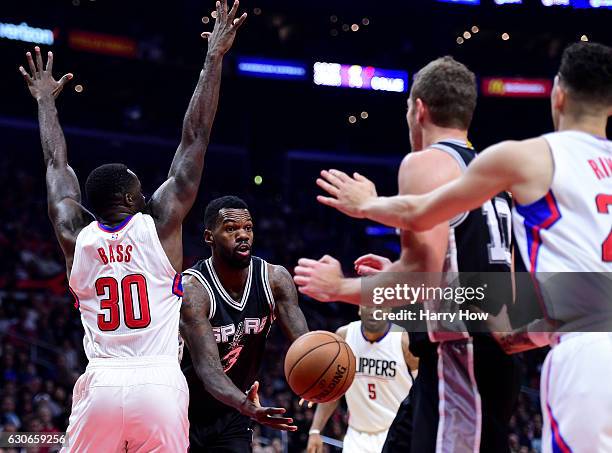 Dewayne Dedmon of the San Antonio Spurs passes around Brandon Bass of the LA Clippers at Staples Center on December 22, 2016 in Los Angeles,...