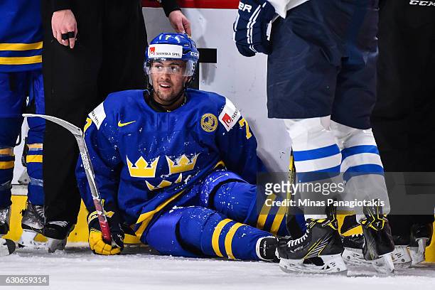 Oliver Kylington of Team Sweden sits on the ice after being hit during the 2017 IIHF World Junior Championship preliminary round game against Team...