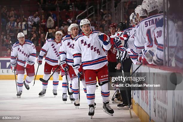 Matt Puempel of the New York Rangers celebrates with teammates on the bench after scoring a power-play goal against the Arizona Coyotes during the...