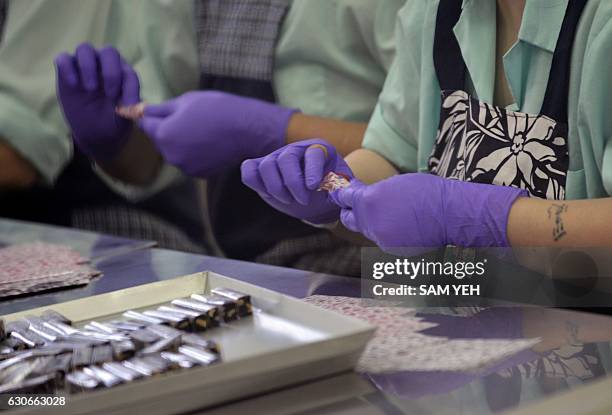 This picture taken on November 24, 2016 shows prisoners packing candy at a correctional facility in Taoyuan, northern Taiwan. If it were not for the...