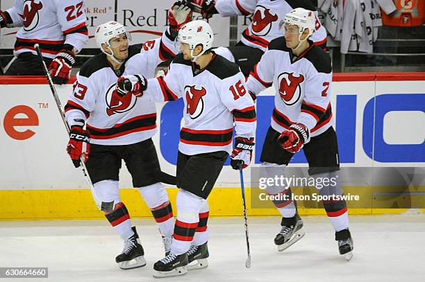 New Jersey Devils center Jacob Josefson is congratulated by defenseman John Moore and defenseman Yohann Auvitu after scoring the game winning goal in...