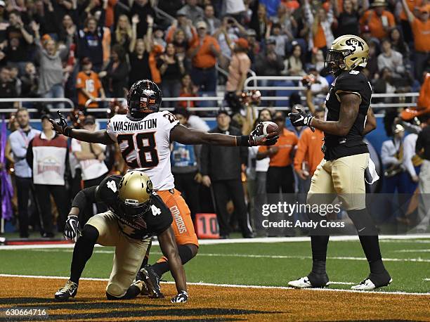 December 29: Oklahoma State Cowboys wide receiver James Washington celebrates his touchdown against Colorado Buffaloes defensive back Chidobe Awuzie...