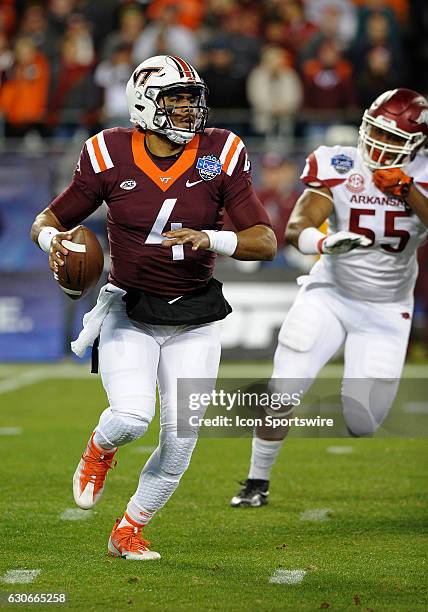 Virginia Tech Hokies quarterback Jerod Evans scrambles out of the pocket as Arkansas Razorbacks defensive lineman Jeremiah Ledbetter chases from...