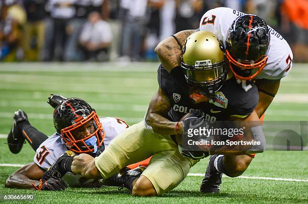Oklahoma State Cowboys safety Kenneth Edison-McGruder and Oklahoma State Cowboys safety Tre Flowers tackle Colorado Buffaloes wide receiver Devin...