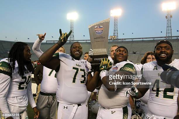 South Florida Bulls offensive lineman Jeremi Hall and others with the trophy after the Birmingham Bowl between the South Carolina Gamecocks and the...