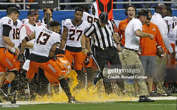 Head coach Mike Gundy of the Oklahoma State Cowboys escapes the gatorade bath from Jordan Sterns of the Oklahoma State Cowboys in the Valero Alamo...