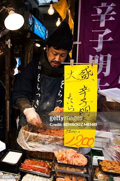 Man prepares some fish eggs for Year-end shoppers at Tsukiji fish market in Tokyo on December 30, 2016. Retailers of essential items for Japan's New...