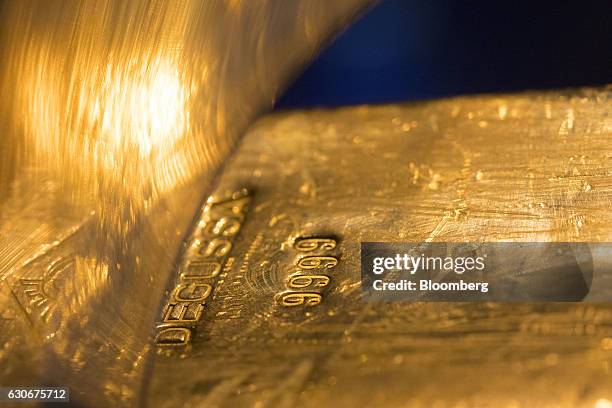 Degussa stamp sits on a gold ingot on display inside the Deutsche Bundesbank's money museum in Frankfurt, Germany, on Thursday, Dec. 29, 2016. German...