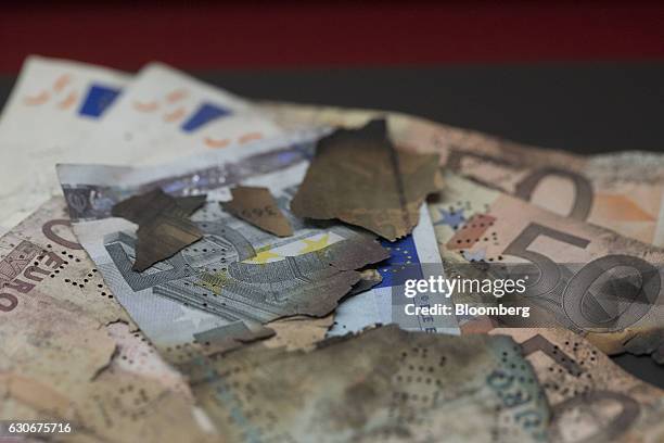 Burnt euro currency banknotes sit on display inside the Deutsche Bundesbank's money museum in Frankfurt, Germany, on Thursday, Dec. 29, 2016. German...