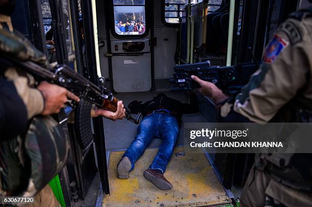 Indian SWAT commando personnel point weapons at a 'terrorist' during a mock drill of bus hijack in New Delhi on December 30, 2016. / AFP / CHANDAN...