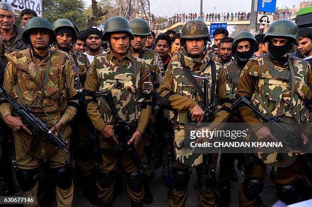 Indian SWAT commando personnel stand guard during a mock drill of bus hijack in New Delhi on December 30, 2016. / AFP / CHANDAN KHANNA