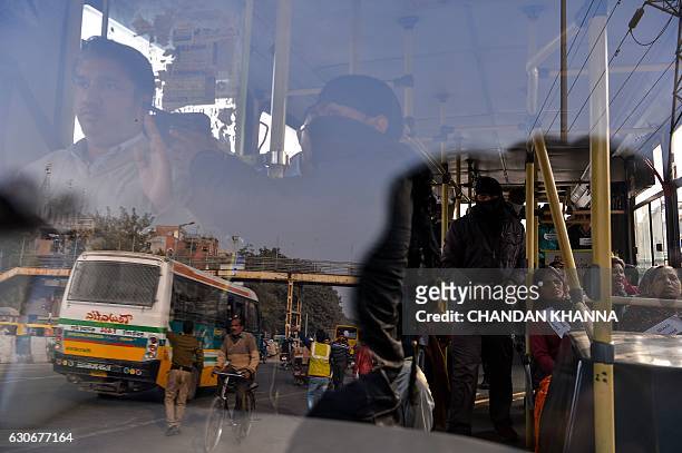 Delhi police personnel dressed as civilians and terrorists take part in a mock drill of bus hijack in New Delhi on December 30, 2016. / AFP / CHANDAN...