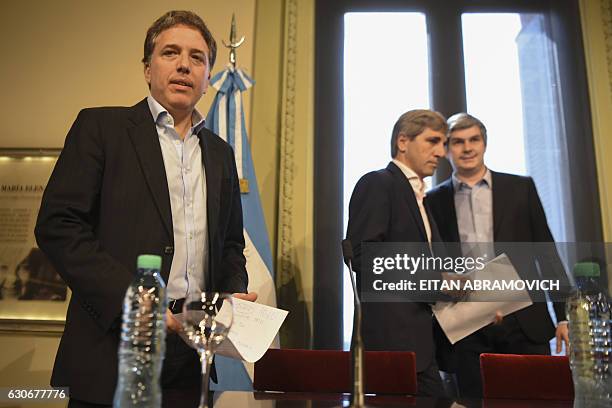 Argentina's new Finance Minister Nicolas Dujovne and Budget Minister Luis Caputo arrive with Chief Cabinet Marcos Pena for a press conference at the...