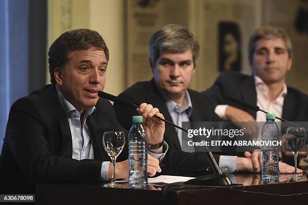 Argentina's new Finance Minister Nicolas Dujovne and Budget Minister Luis Caputo offer a press conference along with Chief Cabinet Marcos Pena, at...