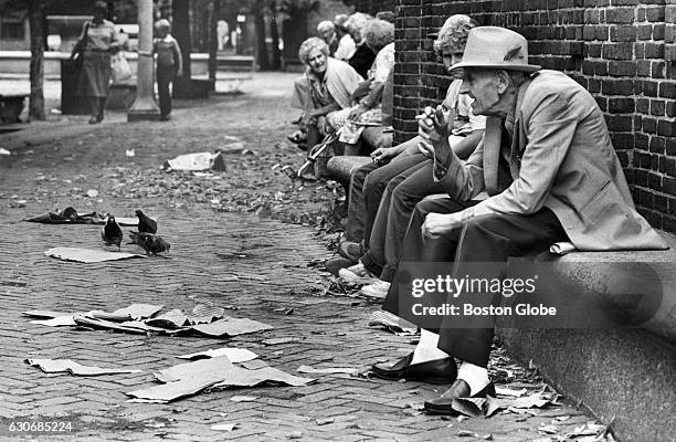 People sit by the Paul Revere Statue on the Paul Revere Mall in Boston's North End on July 30, 1981.