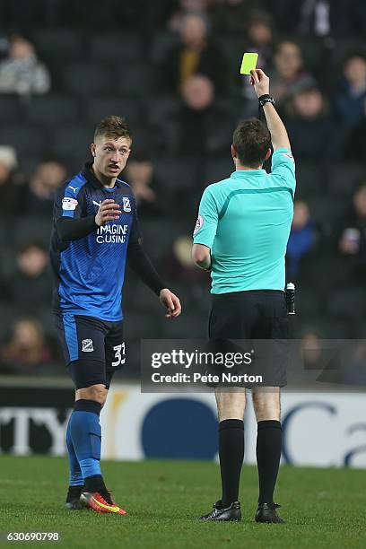 Luke Norris of Swindon Town is shown a yellow card by referee Ben Toner during the Sky Bet League One match between Milton Keynes Dons and Swindon...