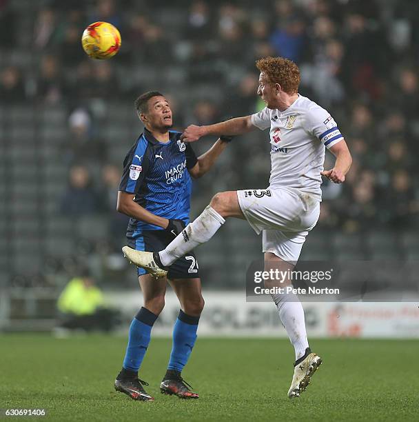 Dean Lewington of Milton Keynes Dons heads the ball away from Jermaine Hylton of Swindon Town during the Sky Bet League One match between Milton...