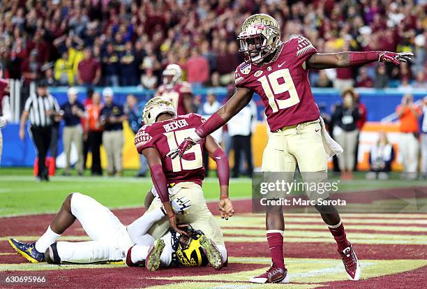 Westbrook and Carlos Becker III of the Florida State Seminoles celebrate breaking up a apass in the second quarter against the Michigan Wolverines...