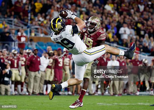 Ian Bunting of the Michigan Wolverines completes a first down pass against the defense of A.J. Westbrook of the Florida State Seminoles in the third...