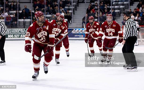 Matt Marcinew of the Denver Pioneers celebrates his first period goal against the Providence College Friars with his teammates Will Butcher, Tariq...