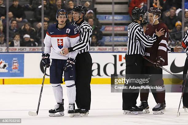 Marian Studenic of Team Slovakia and Kristaps Zile Captain of Team Latvia have to be separated by officials during the 3rd period in a preliminary...