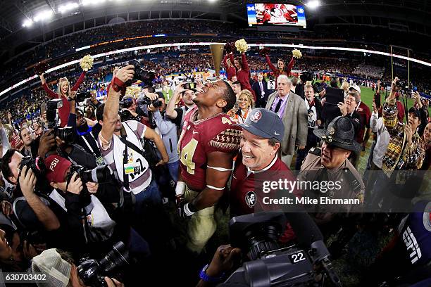 DeMarcus Walker and head coach Jimbo Fisher of the Florida State Seminoles celebrate their 33 to 32 win over the Michigan Wolverines during the...